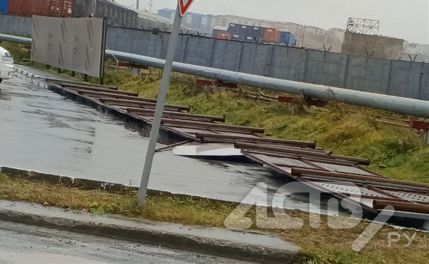 Новый забор повалило ветром на тротуар в Корсакове